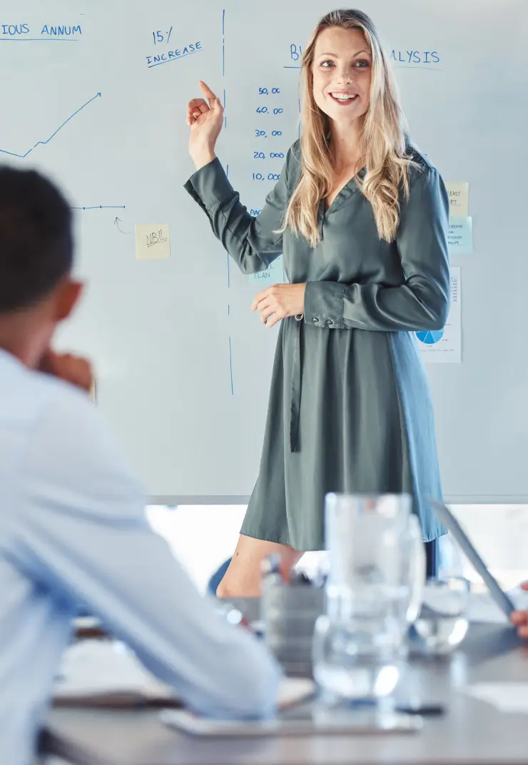 Smiling woman presenting data analysis to team using whiteboard during business meeting
