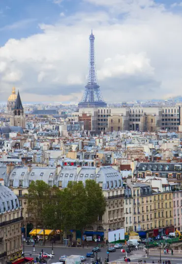 Scenic view of Paris with the Eiffel Tower rising above classic city rooftops and historic architecture