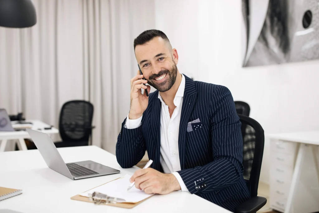 smiling luxury real estate agent in suit with beard working